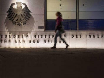 Person walking in front of the building of the German Federal Ministry of the Interior.
