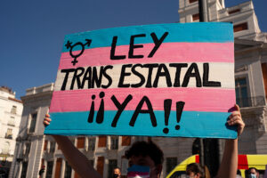Self-determination: Protester holding up a banner that says 'Ley trans estatal ya', 'State trans law now'
