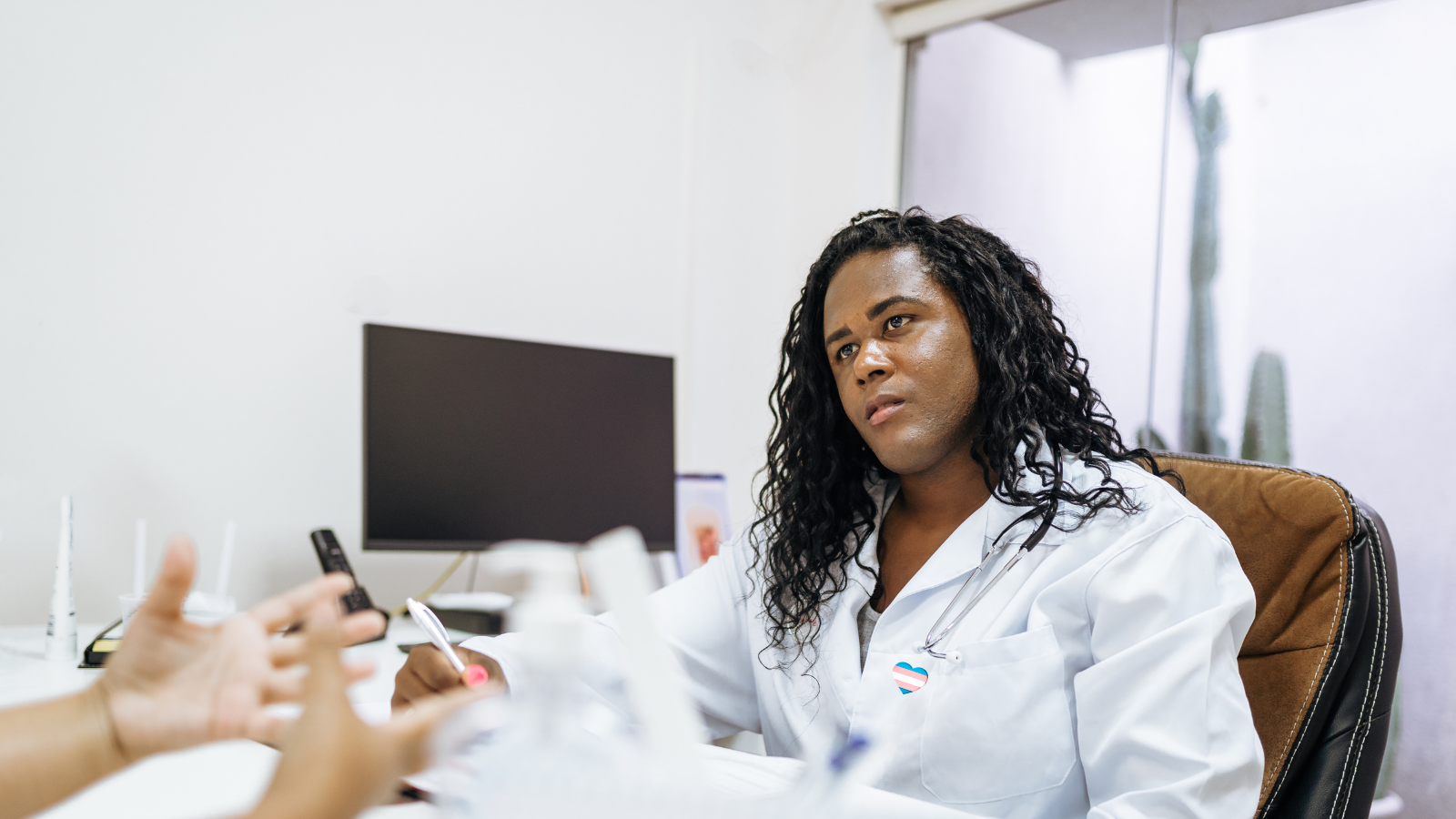 A trans doctor consults with a patient.