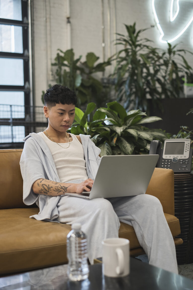 A non-binary person using a laptop at work