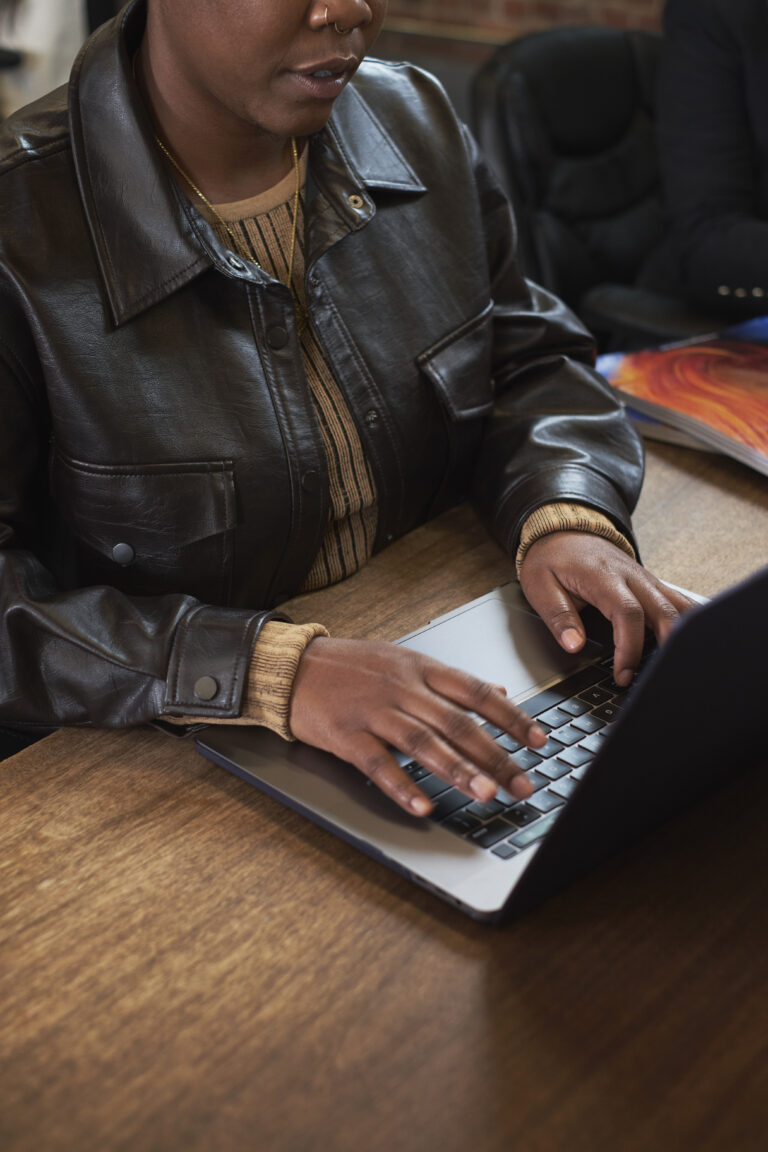 A trans person working on a laptop in an office