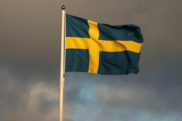 Swedish flag waving in cloudy sky