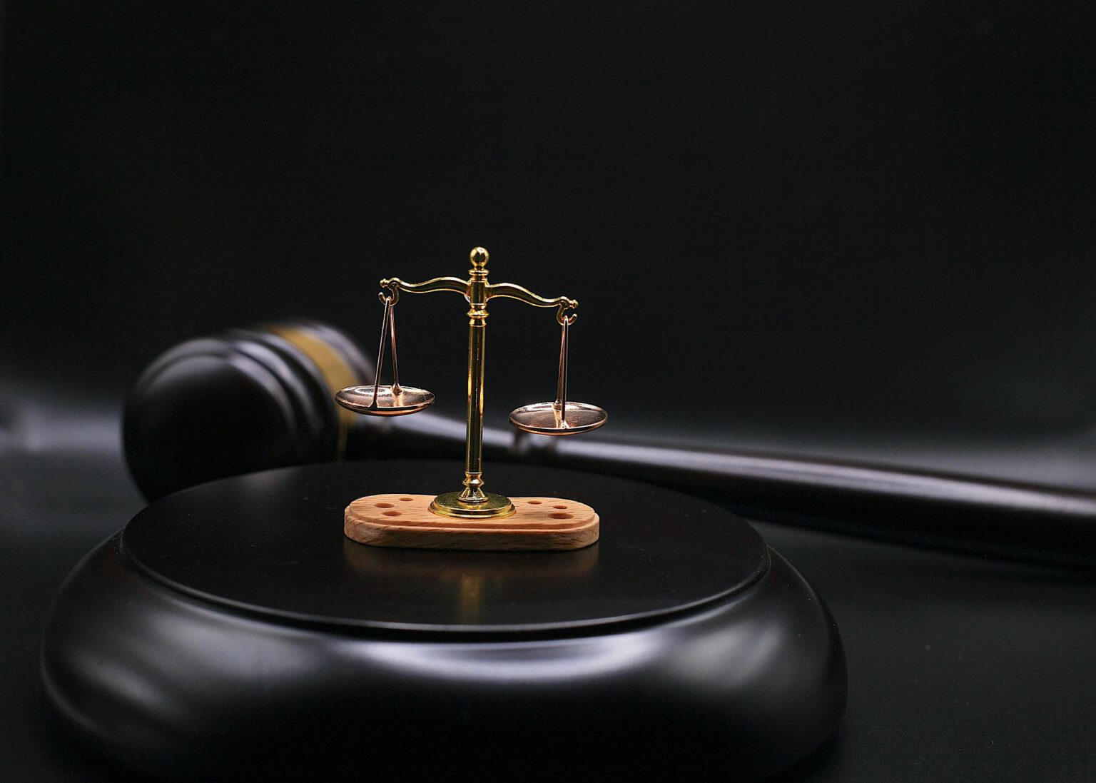 Gavel and justice scale on a dark legal background.